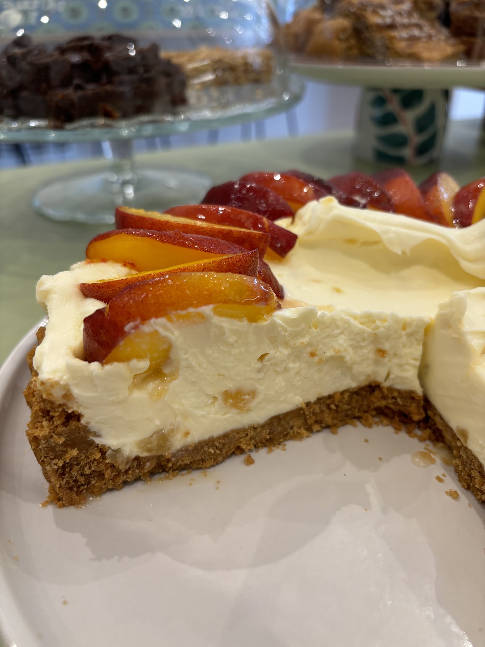 Creamy cheesecake topped with glazed stone fruit slices at The Coffee Tree