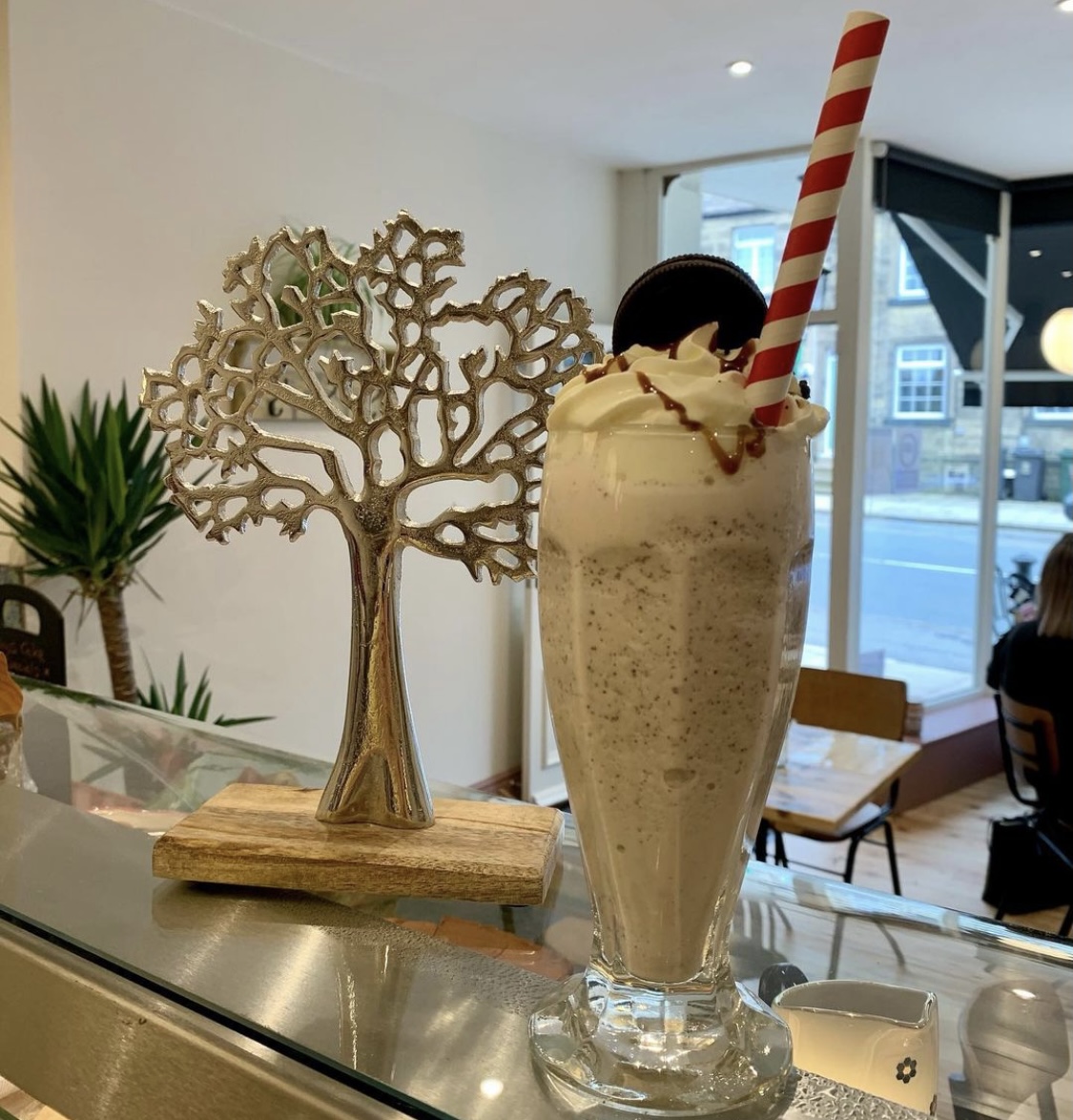 A tall milkshake with whipped cream on the café counter at The Coffee Tree